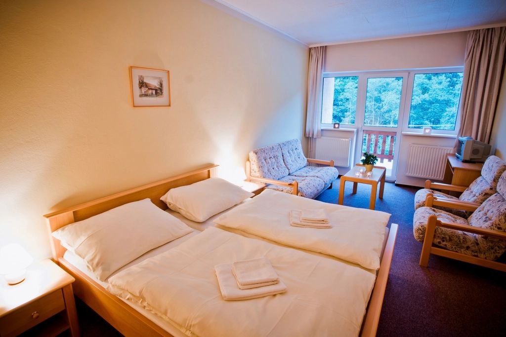 A guest room with a large bed and soft lighting